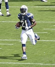 In team warmups and in full Chargers uniform, LaDainian Tomlinson runs with the ball.