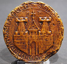A round seal depicting the walls of a town with two towers and a gate, and the tower of a church