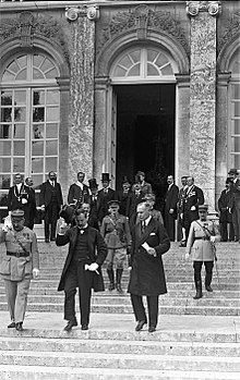 A szerződés magyar aláírói Benárd Ágost küldöttségvezető (balra, cilinderrel a kezében) és Drasche-Lázár Alfréd rendkívüli követ, államtitkár (jobbra, fedetlen fővel) távoznak az aláírás után