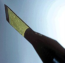 A diamond scalpel consisting of a yellow diamond blade attached to a pen-shaped holder