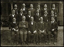 photo en noir et blanc d'hommes en costume alignés sur trois rangs