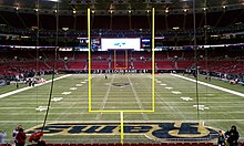 Photograph of a football field taken from the end zone showing goal posts in the foreground