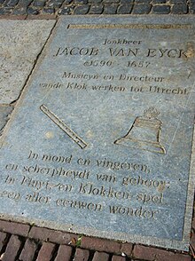 A stone slab in the sidewalk etched with words that dedicate it to Van Eyck