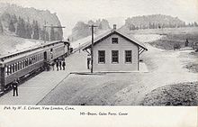 A postcard of a train at a small wooden railway station
