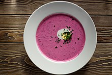 A bowl of creamy pink soup with half or hard-boiled egg, sprinkled with chopped chives