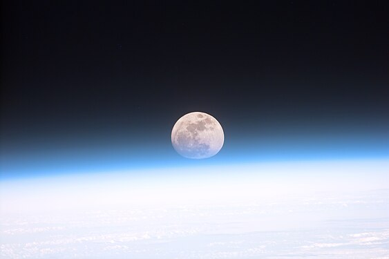 Astronauts aboard the Space Shuttle Discovery recorded this rarely seen phenomenon of the full Moon partially obscured by the atmosphere of Earth. The image was recorded with an electronic still camera at 15:15:15 GMT, Dec. 21, 1999. (Credit: NASA.)