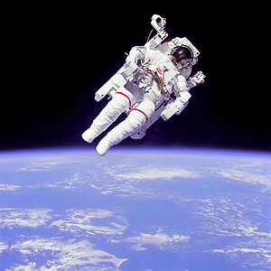 رائد الفضاء "بروس ماكاندليس " مرتديا رداء الفضاء، ولابسا فوقه وحدة مأهولة للمناورة خارج مركبة الفضاء. الصورة من عام 1984، ناسا.