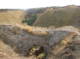 Ров являвшийся подошвенной частью сооружений вала, фрагменты остатков вала справа и руины моста через ров со стороны Чёрного моря.