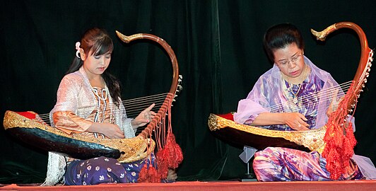 Two female musicians play the saung at a performance in Mandalay.