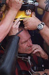 A diver being helped out of his bulky diving gear