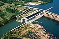 Aerial photograph of the navigation locks at Wilson Dam, with the shore to the left and the dam wall to the right.