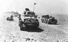 Armored vehicle convoy moving through a dessert