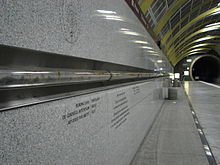 A glass tube containing geological samples including some from Boring Lava Field is seen running along the wall of the Washington Park station platform.