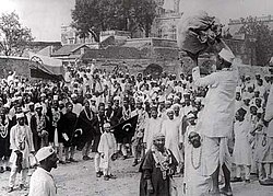 Hindus and Muslims, displaying the flags of both the Indian National Congress and the Muslim League, collecting clothes to be later burnt as a part of the non-co-operation movement initiated by Gandhi.