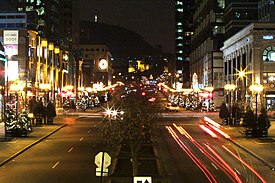 A view of McGill College Avenue in December, looking north. The Mount Royal Cross is visible in the background.
