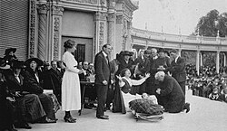 Aimee Semple McPherson conducting a healing ceremony at the Spreckels Organ Pavilion in 1921. Police support, along with U.S. Marines and Army personnel, helped manage traffic and the estimated 30,000 people who attended.